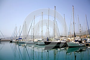 Yacht parking in harbor, harbor yacht club in Agios Nikolaos, Crete, Greece. Beautiful Yachts in blue sky background