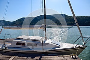 Yacht on pier near the shore on the lake