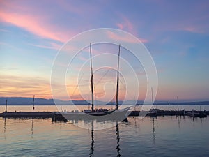 Yacht in port over rose colored sunset