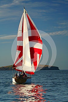 The Yacht with a red sail near island. 2