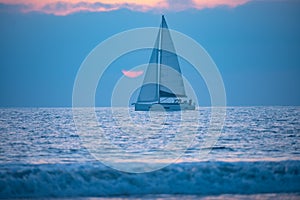 Yacht sailing against sunset. Landscape with skyline sailboat and sunset silhouette. Yachting tourism. Romantic trip on