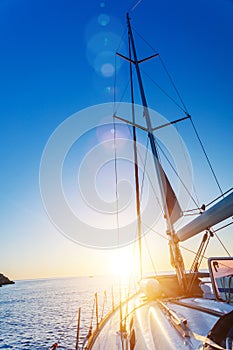 Yacht Sailing against sunset. Sailboat. Travel Concept