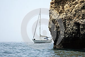 Yacht sailing by cliff