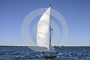 Yacht sailing on Lake Ontario on one sail.