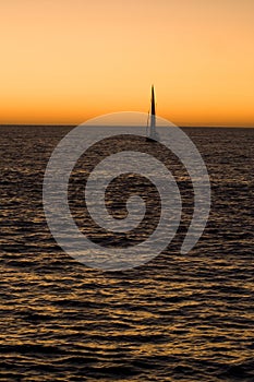 Yacht sailing in sea at sunset