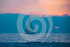 Yacht sailing in the sunrise time. Sea landscape view with a beautiful sailboat. Yachting tourism sea voyage on the sail