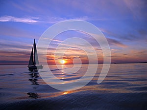 Yacht sailing at sunset photo