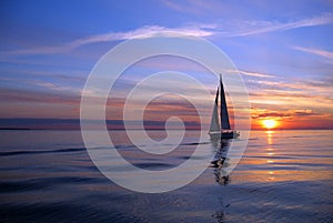 Yacht sailing at sunset photo