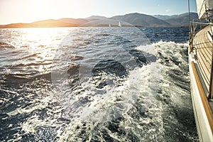 Yacht sailing towards the sunset. Luxury yachts.