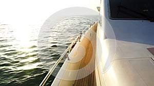 Yacht sailing towards the sunset. Sailing boat deck with hoisted sails and teak deck. Stock. Sailing yacht boat on on