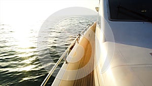 Yacht sailing towards the sunset. Sailing boat deck with hoisted sails and teak deck. Stock. Sailing yacht boat on on