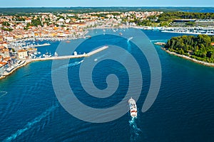 Yacht sails towards sea bay with Rovinj town on peninsula