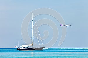 Yacht in sea and airplane on blue sky