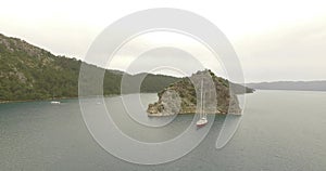 Yacht in the sea surrounded by rocks