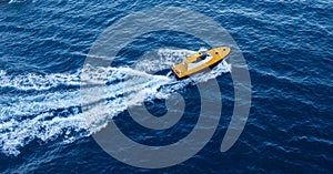 Yacht in the sea. Water splash, waves, yellow motorboat for recreation or entertainment, fishing, cruise, swim, nature