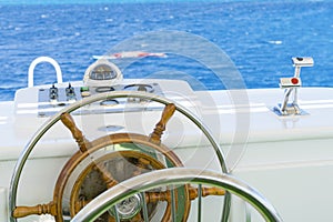 Yacht steering wheel on blue sky background. The yacht`s steering wheel sails on the sea