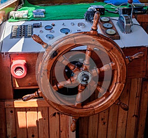 Yacht steering wheel and control panel. Ready to sea travel. Wooden deck interior of sailing boat. Ship on pier. Good
