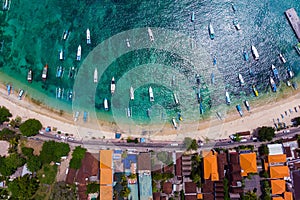 Yacht and tourist boat on the blue sea water in a tropical lagoon near the coastline on which there are buildings and