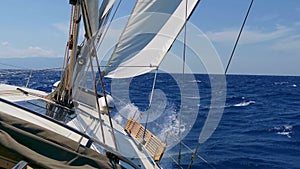 Yacht Under Sails racing across the sea on a sunny summer day. Vacation and Sailing