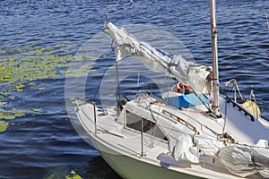 Yacht with a white sail on the blue water. Part of the frame