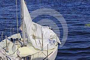 Yacht with a white sail on the blue water. Part of the frame