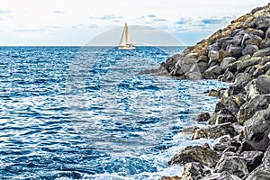 A yacht with white sails sailing on the blue water of the Atlantic Ocean