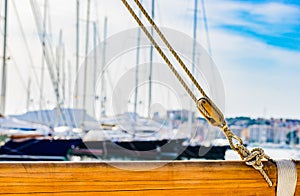 Yachting, pulley nautical ropes rigging on wooden mast