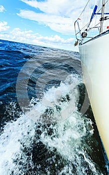 Yachting on sail boat bow stern shot splashing water