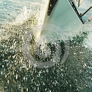 Yachting on sail boat bow stern shot splashing water