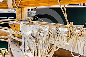 Yachting, wooden classical sailing boat, close-up of tied nautical ropes on wood cleats