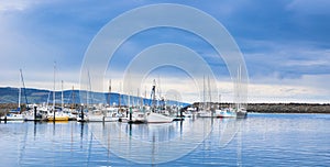 Yachts anchored in a marina with a stormy sky