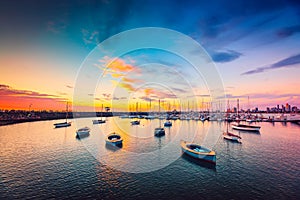 Yachts anchored in a row at sunset