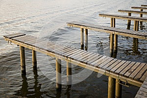 Yachts and boat berths with empty spaces. Coastal landscape in background photo