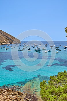 Yachts and boats moored on the small bay with clear turquoise water