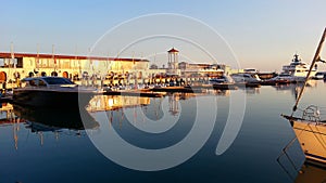 Yachts and boats at the pier, reflections in water