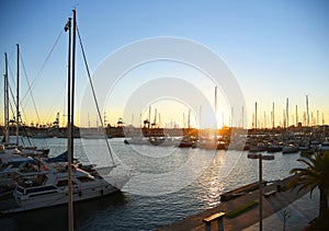 Yachts and boats in silhouette of sunset in Marina.