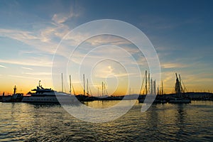 Yachts floating in a harbor on sunset.