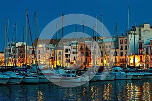 Yachts and illuminated houses in the evening in Ibiza