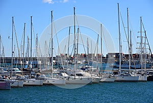Yachts and motor boats in La Marina de Valencia, Spain. Luxury yacht and fishing motorboat in yacht club at Mediterranean Sea.