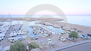 Yachts are parked at the pier at sunset. Skyline and boats on the waterfront