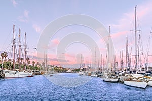 Yachts and pirate ships are moored in the port of Barcelona at sunset, Spain