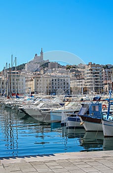 Yachts in the port of Marseilles on the background of the church of Notre Dame de la Garde