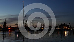 Yachts sailboats in marina harbour. Sail boat masts in twilight. Dusk in harbor, California USA.