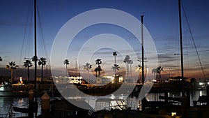 Yachts sailboats in marina harbour. Sail boat masts in twilight. Dusk in harbor, California USA.