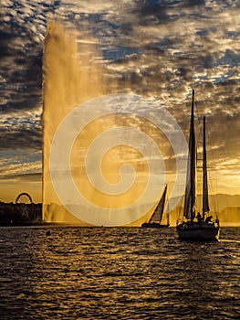 Yachts sailing into the harbour of Geneva, Switzerland at sunset.