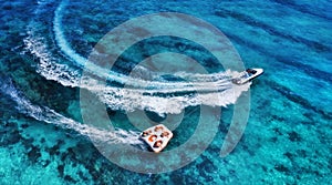 Yachts at the sea surface. Aerial panoramic view of luxury floating boat on transparent turquoise water at sunny day. Top view fro