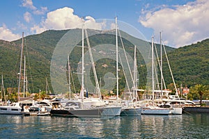 Yachts on water against background of mountains. View of yacht marina of Porto Montenegro. Montenegro, Bay of Kotor, Tivat city