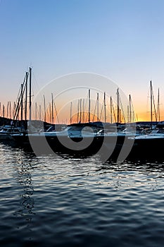 Yachts on water at pier at sunset