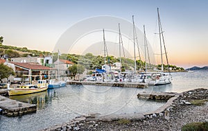 Yachts and wooden fishing boats in the bay of the Adriatic sea and dining people under a canopy in a fishing village in Lavsa, photo
