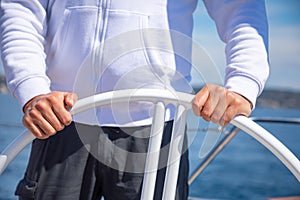 Yachtsman holding the wheel on a sailing boat during yachting, Croatia